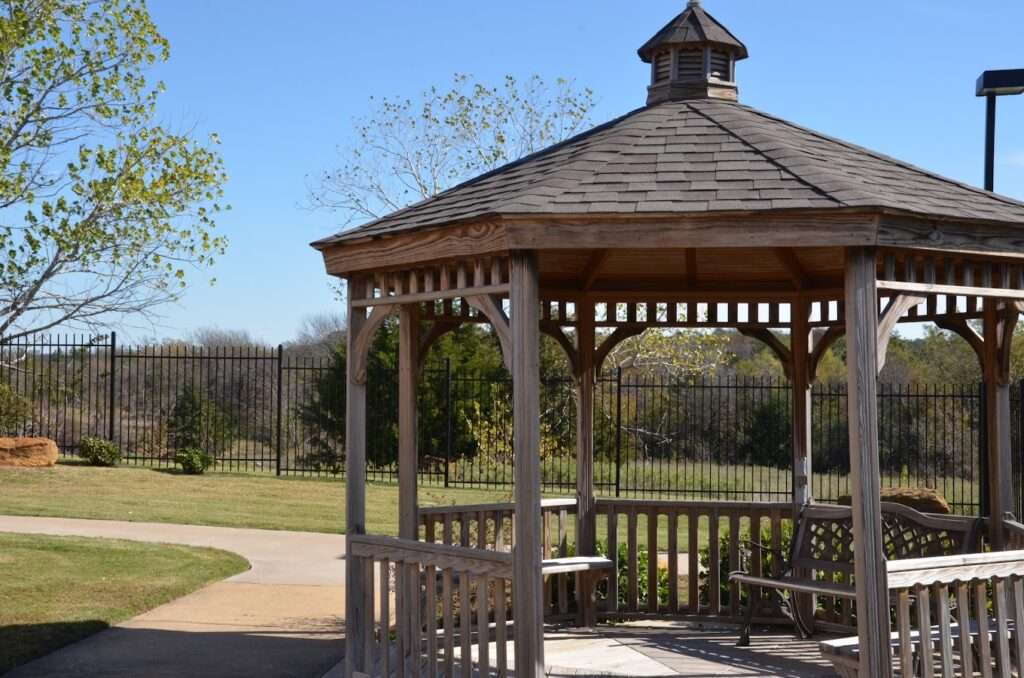 A park gazebo at the Homestead of Denison, TX, surrounded by greenery and open space